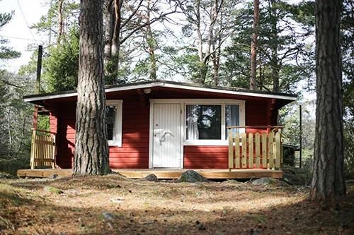 A red cottage on a forest area in Rumarstran